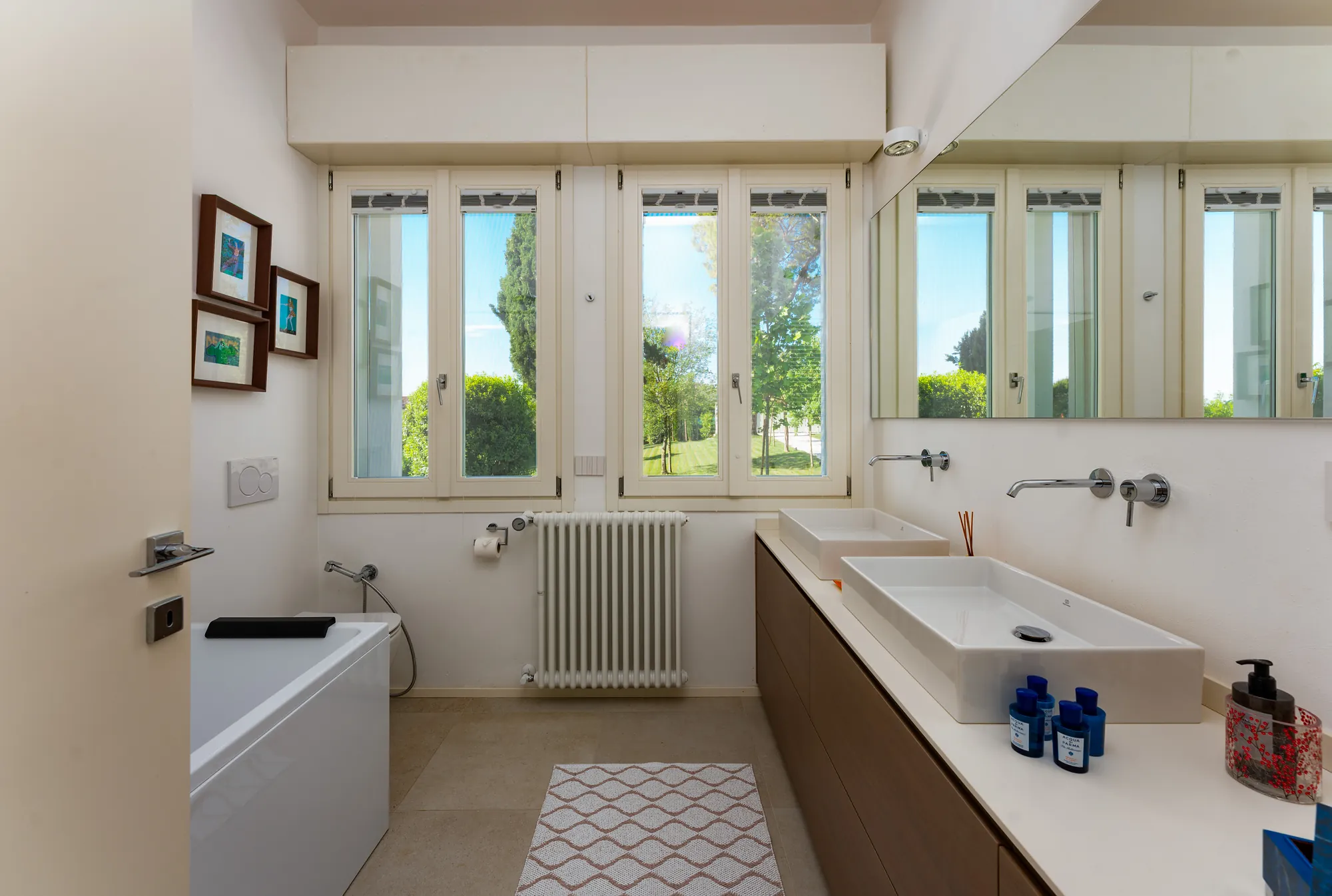 En-suite bathroom with bathtub, double vanity and windows onto the garden